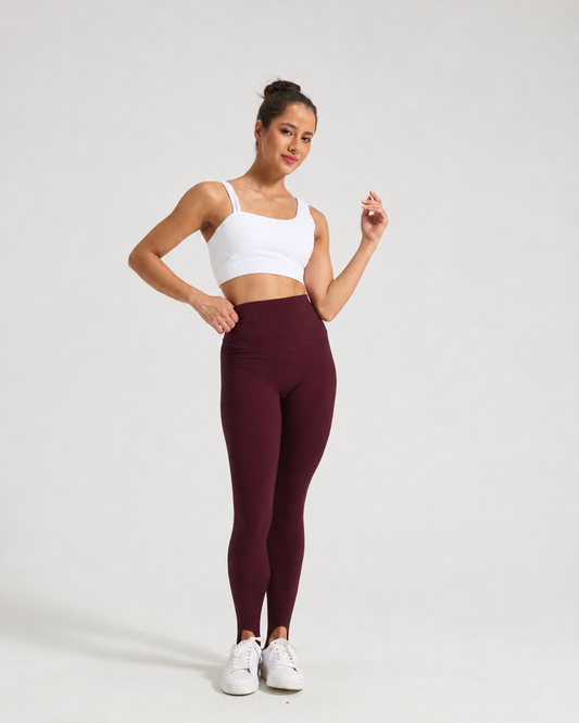 Model wearing Angola Red Formwynn stirrup leggings with a white top and trainers