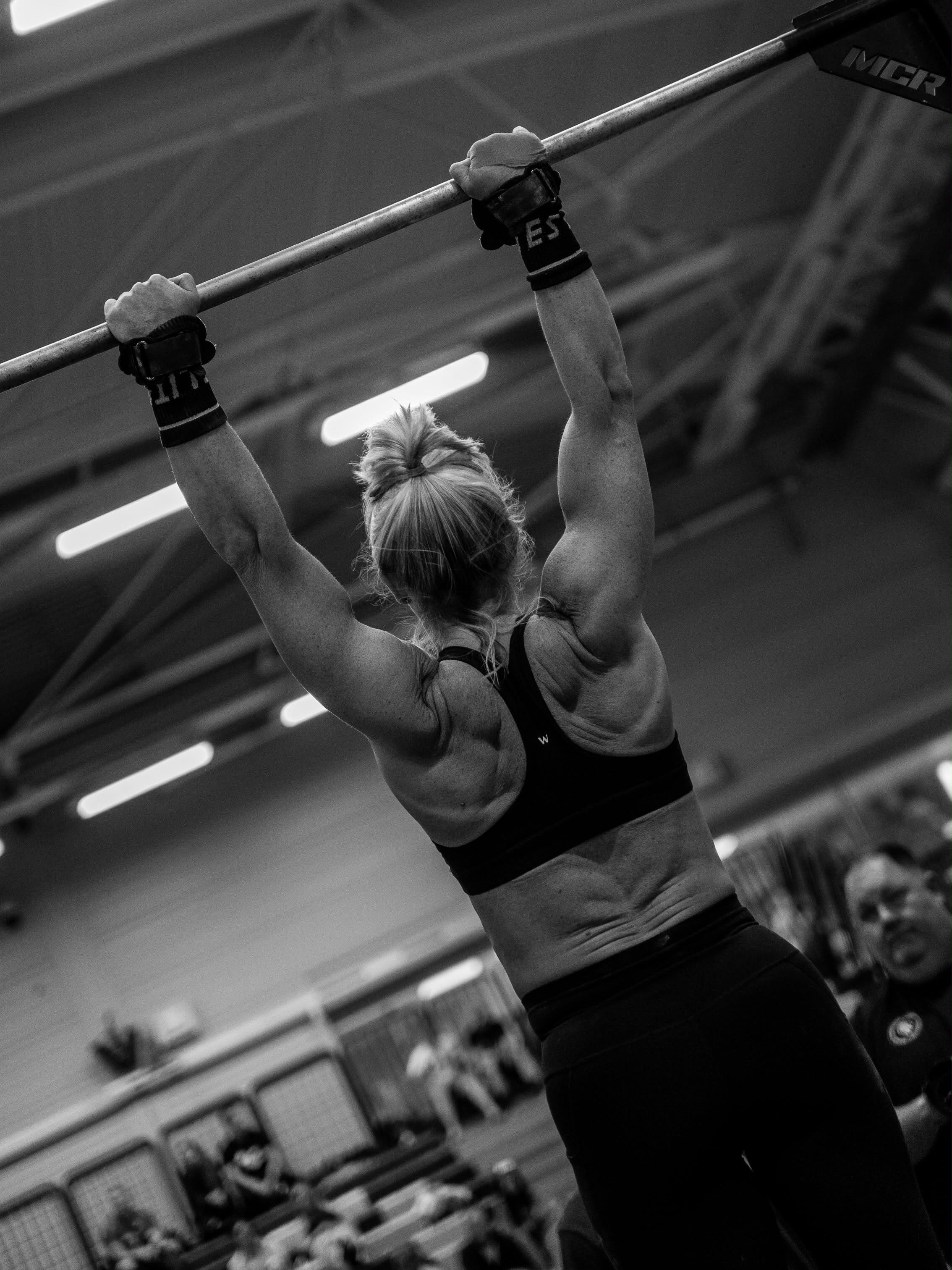 Athlete holding a pull-up bar in a black performance set