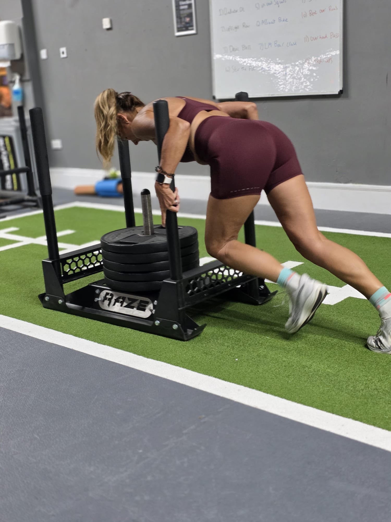 Athlete driving a weighted sled in a Burgundy training set